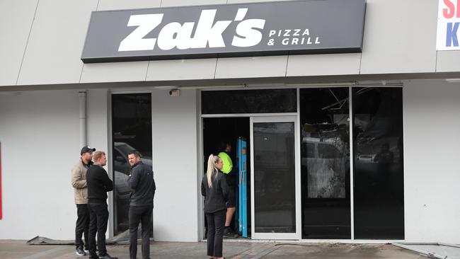 People outside Zak's Pizza and Grill at the Happy Valley Shopping Centre after it was destroyed in an arson attack on Tuesday. Picture: Tait Schmaal