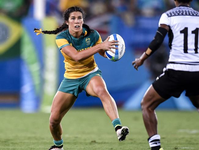 Australia's Charlotte Caslick runs with the ball in the women’s rugby sevens match between Australia and Fiji during the Rio 2016 Olympic Games at Deodoro Stadium in Rio de Janeiro on August 6, 2016. / AFP PHOTO / PHILIPPE LOPEZ