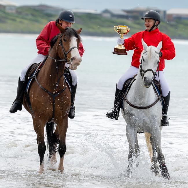 Port Fairy, VIC: Beach vibes and Melbourne Cup magic merge as Anne McGrath and Leo Dwyer take a leisurely ride through the surf. Picture: Jay Town