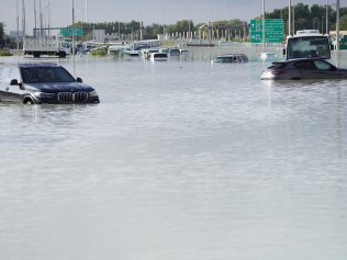 Vehicles sit abandoned in floodwater covering a major road in Dubai, United Arab Emirates, Wednesday, April 17, 2024. Heavy thunderstorms lashed the United Arab Emirates on Tuesday, dumping over a year and a half's worth of rain on the desert city-state of Dubai in the span of hours as it flooded out portions of major highways and its international airport. (AP Photo/Jon Gambrell)