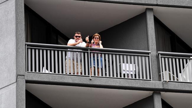 Quarantined guests wave from their balcony at the Hotel Grand Chancellor in Spring Hill, Brisbane. Picture: Dan Peled