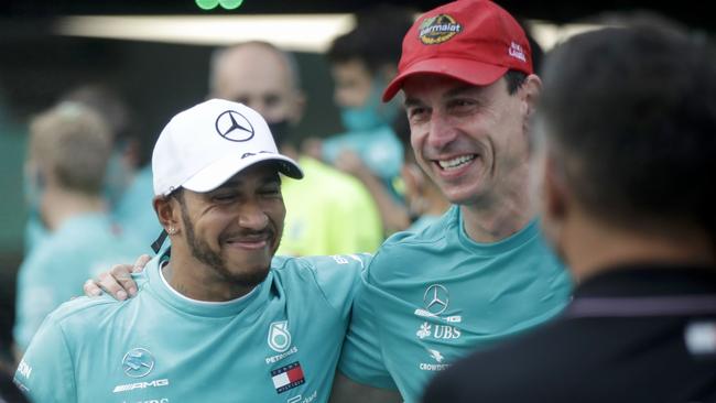 Mercedes' British driver Lewis Hamilton (L) poses with Toto Wolff,