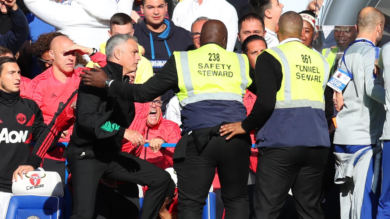 Stewards hold back Jose Mourinho, Manager of Manchester United as he clashes with the Chelsea backroom staff