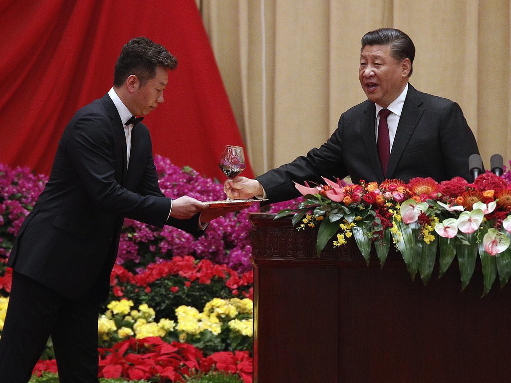 Xi Jinping, right, takes a glass of wine to make a toast after his speech at a dinner marking the 70th anniversary of the founding of the People's Republic of China. Picture: AP