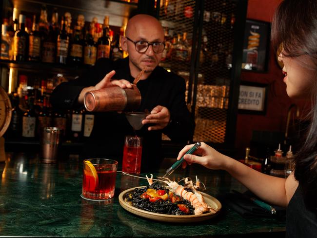 DAILY TELEGRAPH. HOLD FOR KC. Bar Conte in Surry Hills has introduced a new menu that is available until 11pm. Pic shows bar tender Enzo Tana at work while a customer eats at the bar. Thursday 14/03/2024. Picture by Max Mason-Hubers
