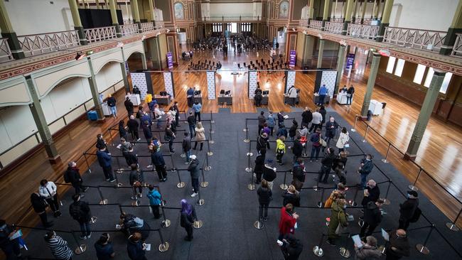 People wait to be register their information before being vaccinated at Melbourne’s Royal Exhibition Building Covid-19 vaccination centre last month. Picture: Getty Images