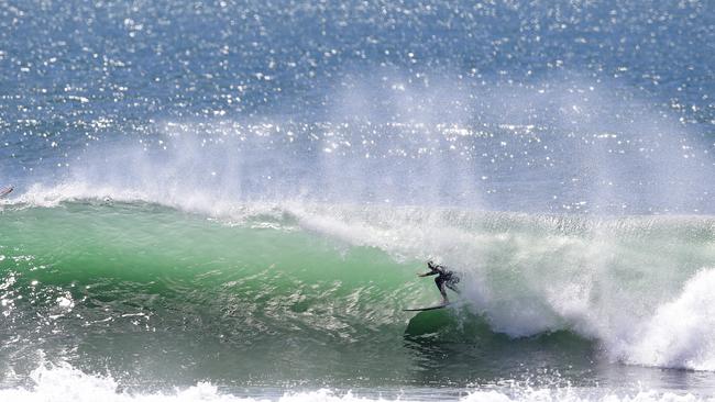 A surfer slotting into one of its famous long, green barrels at Kirra. Picture: Luke Marsden