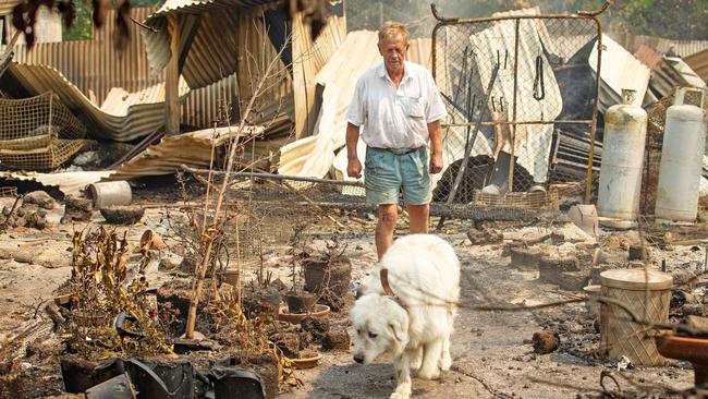 Rex Newton, 69, surveys the remains of his Bunyip North home of 40 years with dog Charlie. Picture: Mark Stewart