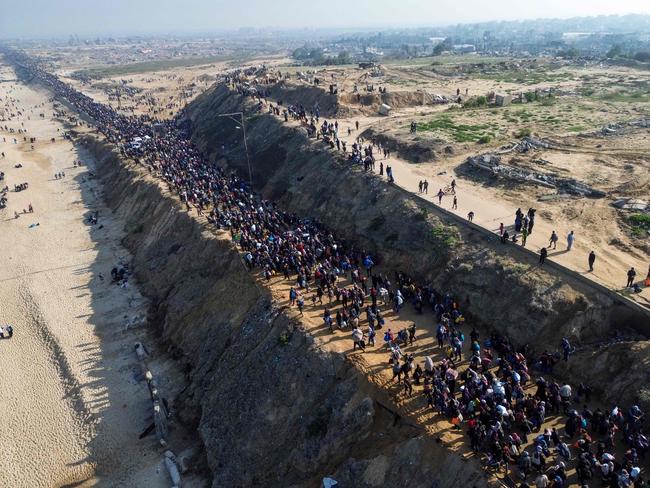 An unending stream of people marched up the coast of Gaza on January 27, carrying their belongings in plastic bags and repurposed flour sacks through the central city of Nuseirat after Israel reopened access to the territory's north. Picture: AFP