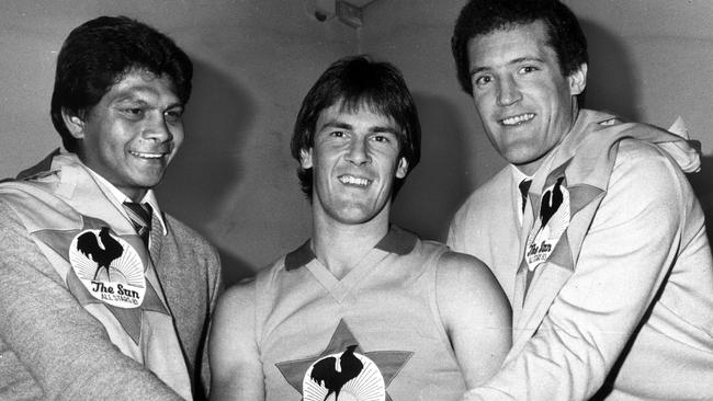 Richmond's Maurice Rioli and North Melbourne's Ross Glendinning with Wallace after he earned an award from The Sun.