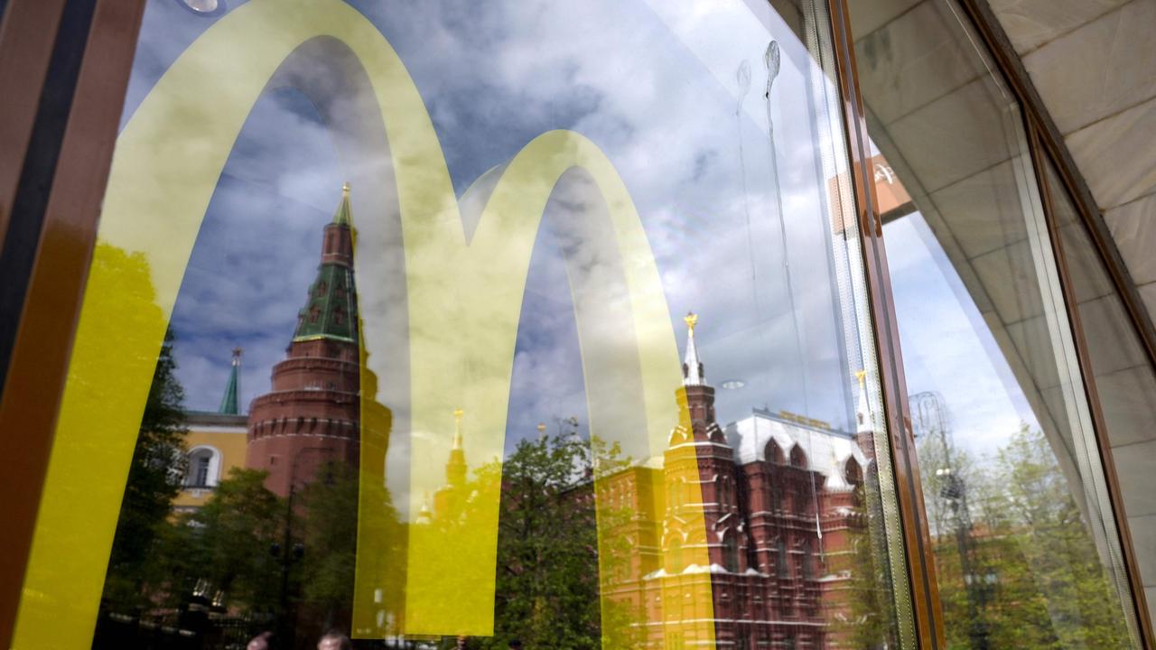 The Kremlin's towers and passers-by are seen reflected in the window of a closed McDonald's restaurant in Moscow after the American fast-food giant announced it will exit the Russian market and sell its business in the increasingly isolated country. Picture: Natalia Kolesnikova/AFP
