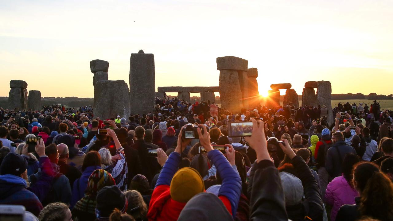 Revellers watch the sunrise as they celebrate the pagan festival of Summer Solstice at Stonehenge in Wiltshire, southern England on June 21, 2018. The festival, which dates back thousands of years, celebrates the longest day of the year when the sun is at its maximum elevation. Modern druids and people gather at Stonehenge every year to see the sun rise on the first morning of summer. Picture: Geoff Caddick