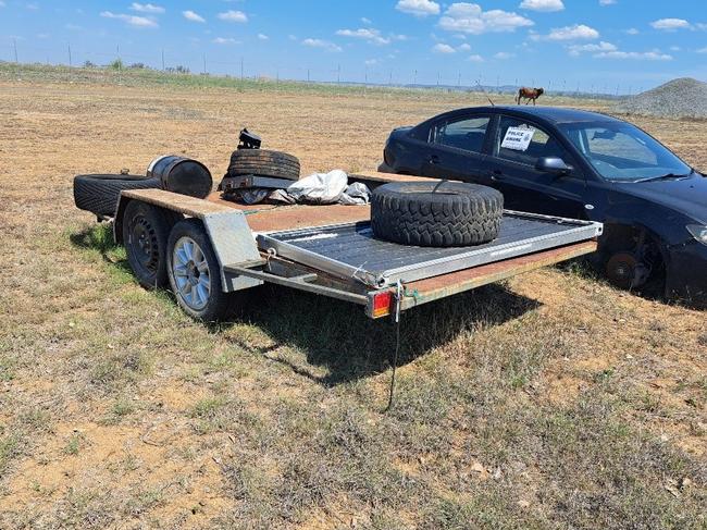 Unregistered, grey dual wheel flatbed trailer.