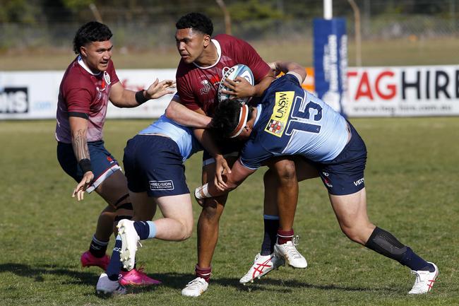 Amare Milford tackled by Waratahs when playing rugby. Picture: John Appleyard