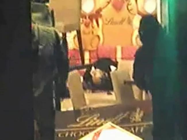 The gunman’s body on the ground as bomb disposal officers enter the cafe