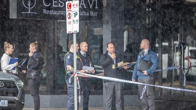 Detectives outside the Preston tobacco shop after it went up in flames. Picture: Jake Nowakowski