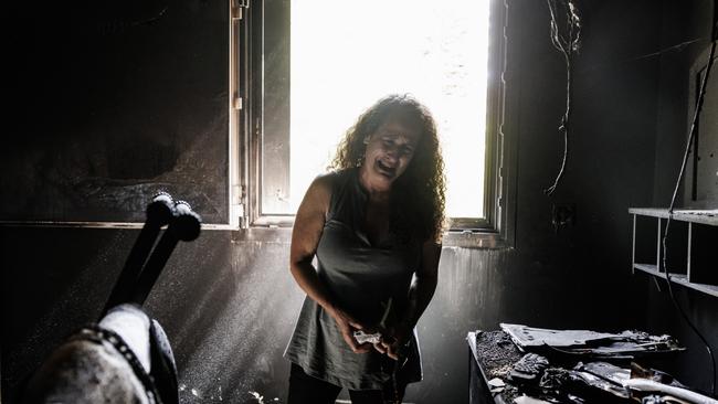 Kibbutz Nir Oz resident Hadas Kalderon, who's children have been taken hostage, and mother and niece killed breaks down in tears while looking through the burnt out home of her late mother Rina Sutzkever.