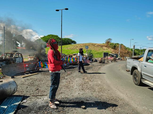 People man a roadblock barricade, with Kanak flags, controlling access to a district in Noumea. Picture: AFP