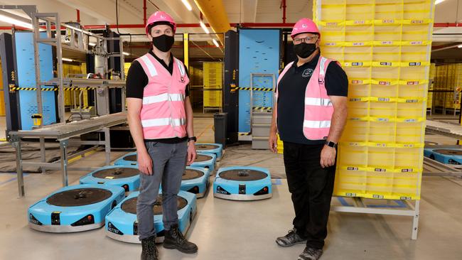 Luke Rector, principal program manager, and Craig Fuller, director of operations, with some of the robots and storage pods used at the new fulfilment centre. Picture: Damian Shaw