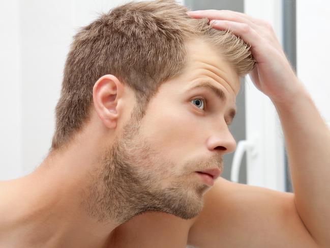 GCB Good Health Guide - generic man looking into a mirror for bald spots