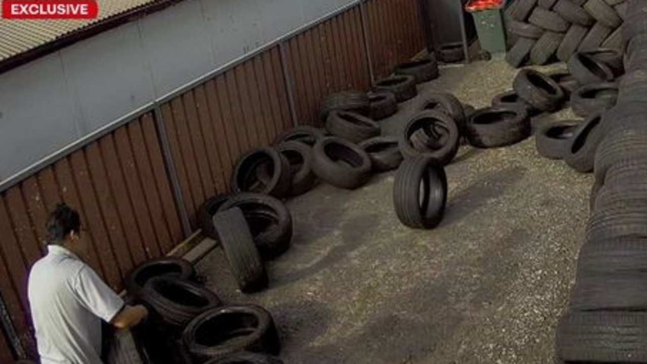 A worker unloads used tyres and stacks them in the Blacktown driveway. Picture: 9 News