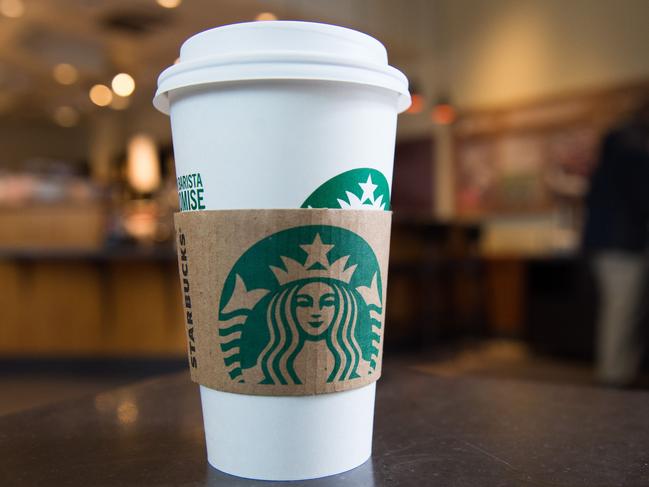 A Starbucks coffee cup is seen inside a Starbucks Coffee shop in Washington, DC, April 17, 2018, following the company's announcement that they will close more than 8,000 US stores on May 29 to conduct 