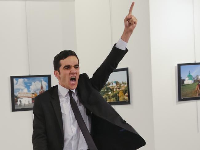 An unnamed gunman gestures after shooting the Russian Ambassador to Turkey, Andrei Karlov, at a photo gallery in Ankara, Turkey, Monday, Dec. 19, 2016. A gunman opened fire on Russia's ambassador to Turkey at a photo exhibition on Monday. The Russian foreign ministry spokeswoman said he was hospitalized with a gunshot wound. (AP Photo/Burhan Ozbilici)