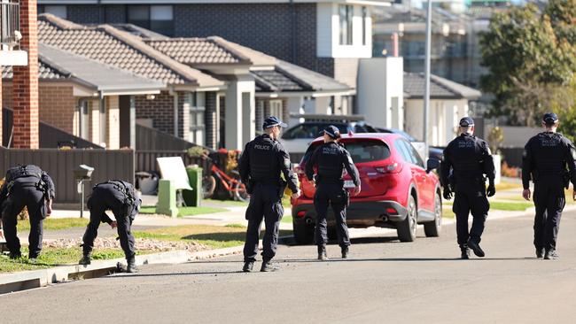 Police doing a line search outside a house in Austral which is believed to have been shot at.