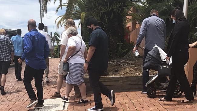 Brendan Piccini (centre, wearing black) walks out of Lismore District Court with a large group of supporters after an earlier court appearance.