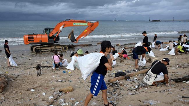 Participants and volunteers remove plastic waste and other garbage washed ashore. Picture: AFP