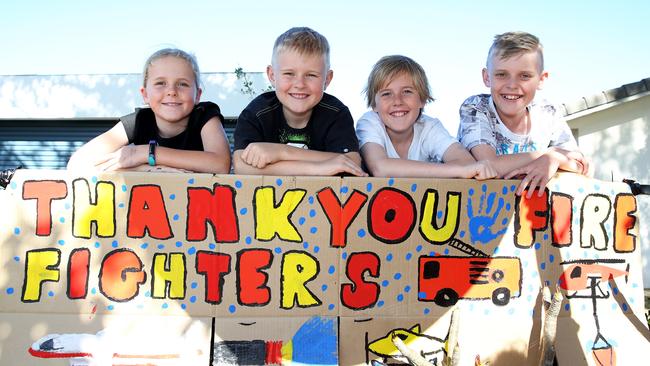 Diamond Beach kids Emily, 9, Michael, 8, Lachlan, 13, and Oliver Castle, 11, made this magnificent thankyou sign for firefighters and have been making them sandwiches and drinks. Picture: Peter Lorimer