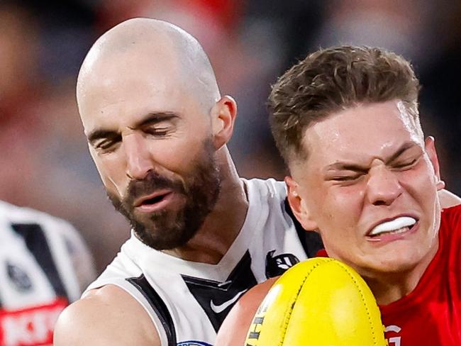 MELBOURNE, AUSTRALIA - AUGUST 23: Taj Woewodin of the Demons is tackled by Steele Sidebottom of the Magpies during the 2024 AFL Round 24 match between the Melbourne Demons and the Collingwood Magpies at The Melbourne Cricket Ground on August 23, 2024 in Melbourne, Australia. (Photo by Dylan Burns/AFL Photos via Getty Images)