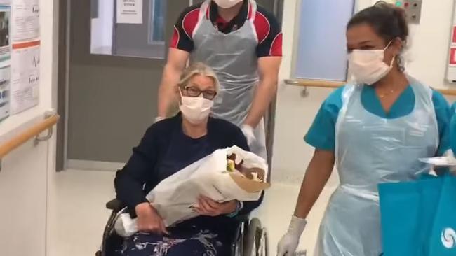 Coronavirus survivor Kym Watkins is wheeled out of Gold Coast University Hospital.