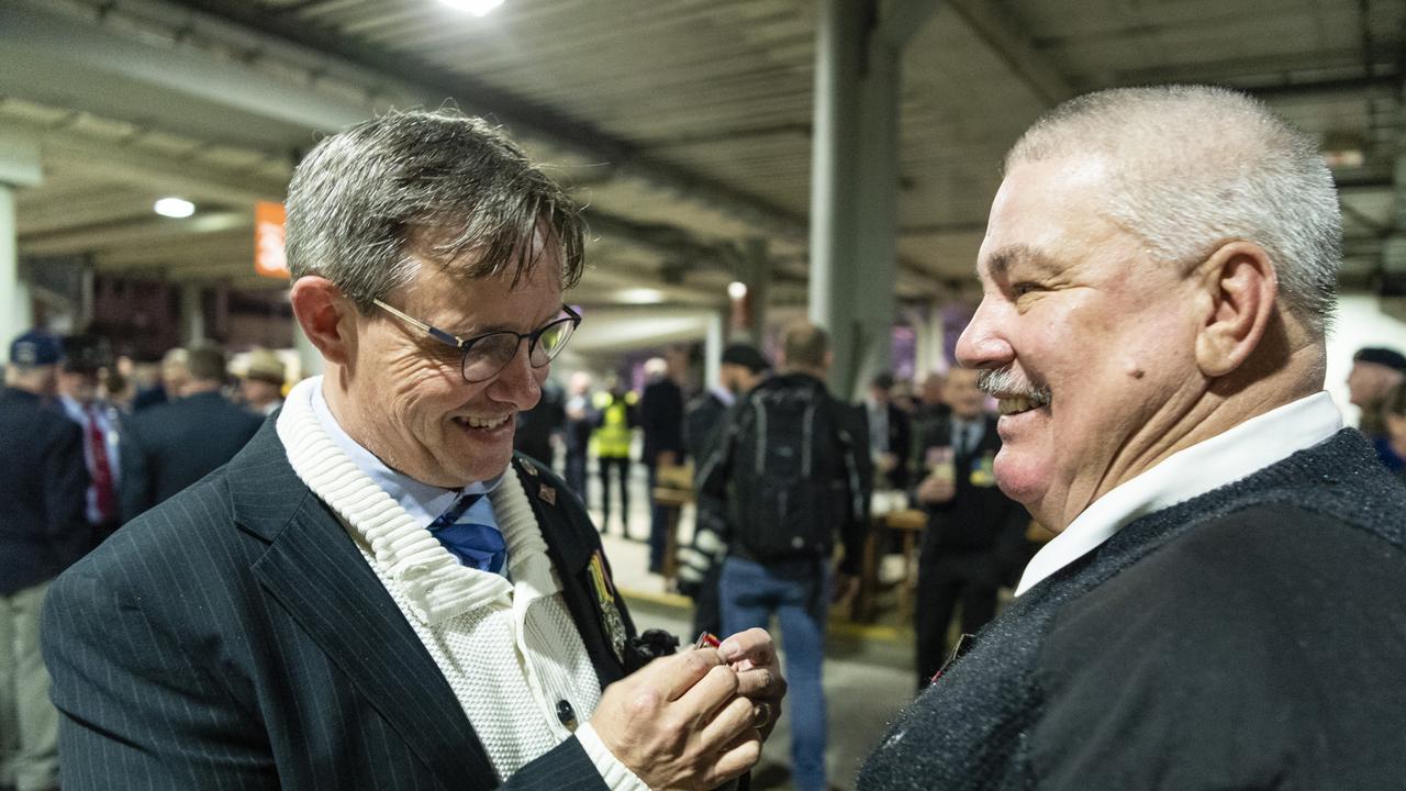 Brian Alderton (left) helps Peter Yarrow pin his and his fathers medals before the Anzac Day dawn service, Monday, April 25, 2022. Picture: Kevin Farmer