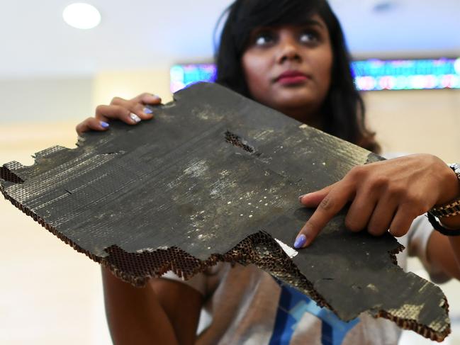 Grace Subathirai Nathan (R), daughter of Malaysian Airlines flight MH370 passenger Anne Daisy, shows a piece of debris believed to be from flight MH370. Picture: Mohd Rasfan