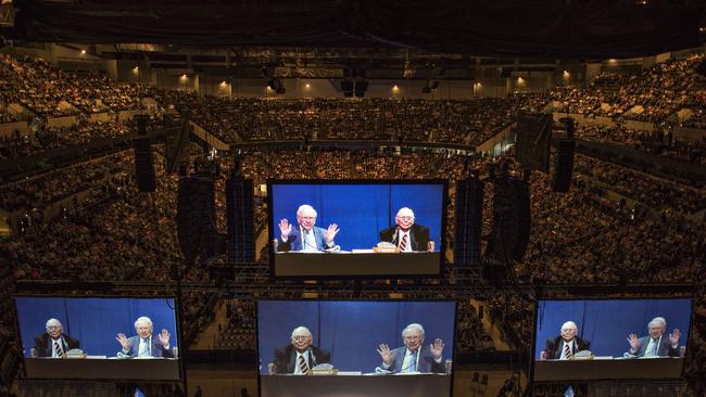 Projections of Warren Buffett, Berkshire Hathaway Inc. chairman and chief executive officer, and Charles Munger, vice chairman of Berkshire Hathaway Inc., appear on large screens above the floor of the Berkshire Hathaway Inc. annual shareholders meeting in Omaha, Nebraska, U.S., on Saturday, May 2, 2015. More than 40,000 people are expected Saturday at the Berkshire Hathaway annual meeting, which marks Warren Buffett's 50th year running the company. Photographer: Daniel Acker/Bloomberg