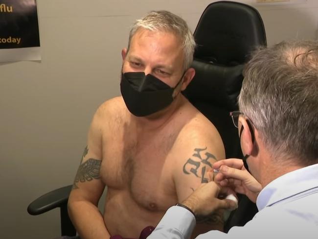 Brett Sutton takes his shirt off to receive his flu vaccination. Picture: Supplied