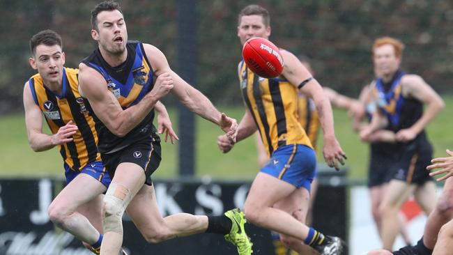 Marc Lock fires off a handball for Old Carey. Picture: David Crosling