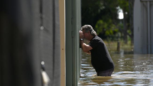 A man checks the condition of his aircraft inside a flooded hanger at an air strip in Grafton on last month. Picture: Saeed Khan / AFP