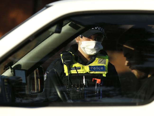 MELBOURNE, AUSTRALIA - JULY 02: Police check the identification of members of the public at a pop up road block in Broadmeadows to ensure they have legitimate reasons for leaving one on the hotspots, July 02, 2020 in Melbourne, Australia. Lockdowns across Melbourne have come into effect for residents of suburbs identified as COVID-19 hotspots following a spike in new coronavirus cases through community transmission. From midnight Wednesday 1 July, residents of 10 postcodes will only be able to leave home have for exercise or work, to buy essential items including food or to access childcare and healthcare. Businesses and facilities in these lockdown areas will also be restricted and cafes and restaurants can only open for take-away and delivery. The restrictions will remain in place until at least 29 July. (Photo by Darrian Traynor/Getty Images)