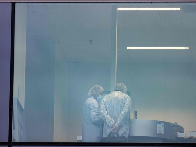 People talk in the offices of a factory of Pfizer, in Puurs, Belgium. The COVID vaccine has reportedly left the factory for Britain. Picture: AFP