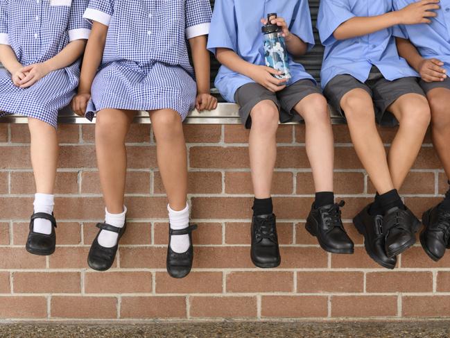 Children's legs and feet in black shoes hanging down Picture: Istock