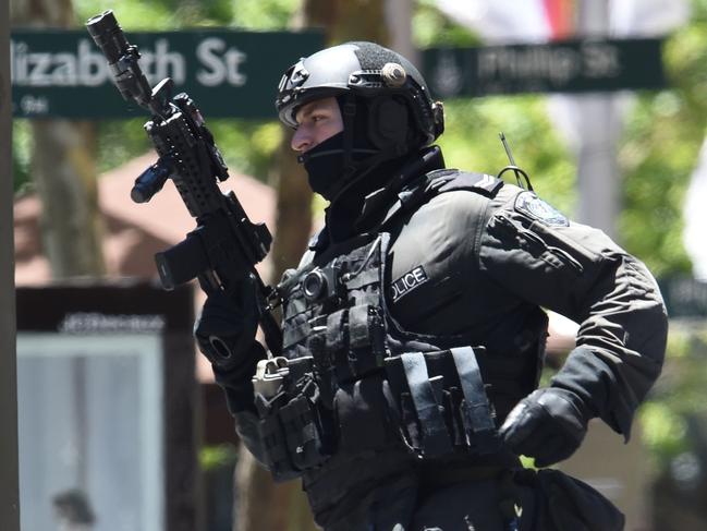 (FILES) This file photo taken on December 15, 2014 shows an armed policeman seen outside a cafe in the central business district of Sydney during a siege.  Police underestimated the threat posed by a self-styled Islamic cleric during a Sydney cafe siege and took too long to storm the building, an inquest found on May 24, 2017, but it absolved them of blame for two deaths. / AFP PHOTO / SAEED KHAN