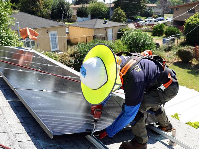 POMONA, CALIFORNIA - OCTOBER 19: GRID Alternatives employee Tony Chang installs no-cost solar panels on the rooftop of a low-income household on October 19, 2023 in Pomona, California. GRID Alternatives has installed no-cost solar for over 29,000 low-income households located in underserved communities which are most impacted by pollution, underemployment and climate change. They are the countryâs biggest nonprofit clean energy technologies installer and operate in California, mid-Atlantic states and Colorado.   Mario Tama/Getty Images/AFP (Photo by MARIO TAMA / GETTY IMAGES NORTH AMERICA / Getty Images via AFP)