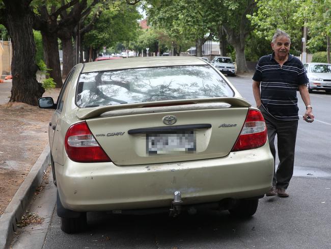 Domenico Demassi, who lives on George St in house adjacent to where the event took place, looks at one of the cars involved in the crash. Picture: Dean Martin