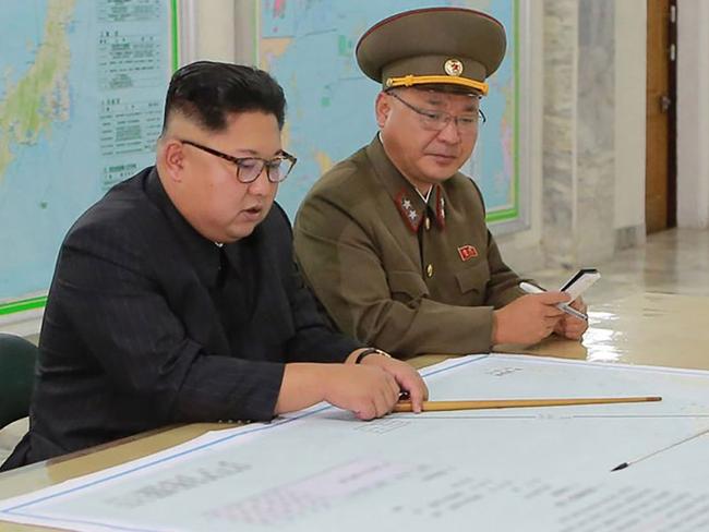 This picture taken on August 14, 2017 and released from North Korea's official Korean Central News Agency (KCNA) on August 15, 2017 shows North Korean leader Kim Jong-Un (C) inspecting the Command of the Strategic Force of the Korean People's Army (KPA) at an undisclosed location. North Korean leader Kim Jong-Un said on August 15 he would hold off on a planned missile strike near Guam, but warned the highly provocative move would go ahead in the event of further "reckless actions" by Washington. / AFP PHOTO / KCNA VIA KNS / STR / South Korea OUT / REPUBLIC OF KOREA OUT   ---EDITORS NOTE--- RESTRICTED TO EDITORIAL USE - MANDATORY CREDIT "AFP PHOTO/KCNA VIA KNS" - NO MARKETING NO ADVERTISING CAMPAIGNS - DISTRIBUTED AS A SERVICE TO CLIENTS THIS PICTURE WAS MADE AVAILABLE BY A THIRD PARTY. AFP CAN NOT INDEPENDENTLY VERIFY THE AUTHENTICITY, LOCATION, DATE AND CONTENT OF THIS IMAGE. THIS PHOTO IS DISTRIBUTED EXACTLY AS RECEIVED BY AFP.  /