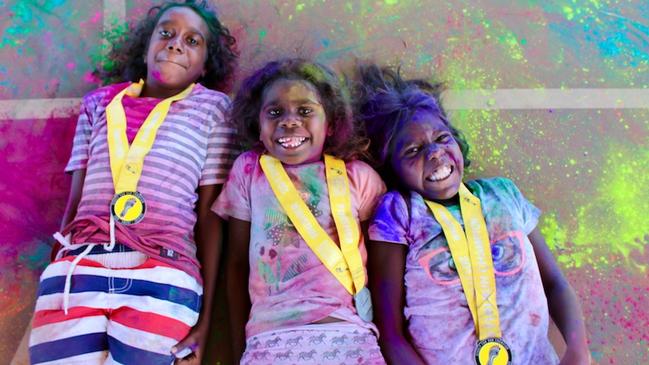 Roshana Herbert, Shatonia Ngalmi and Joyce Bara Bara take part in a fun colour event in Umbakumba, organised to help combat anti-social behaviour.