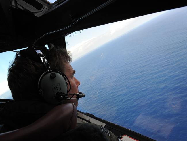 (FILES) This file photo taken from a Royal New Zealand Airforce (RNZAF) P-3K2-Orion aircraft on April 13, 2014 shows co-pilot and Squadron Leader Brett McKenzie helping to look for objects during the search for missing Malaysia Airlines flight MH370, off Perth. The official search for MH370 may have been called off but experts believe the missing airliner will one day be found, perhaps either by deep-sea miners or treasure hunters lured by a huge cash reward. After spending almost three years and 150 million USD on a deep sea hunt for the Malaysian passenger jet in the remote Indian Ocean off western Australia, top aviation investigators have been forced to admit they have come up with nothing.  / AFP PHOTO / POOL / GREG WOOD / TO GO WITH Australia-Malaysia-China-MH370-aviation,FOCUS by Glenda KWEK