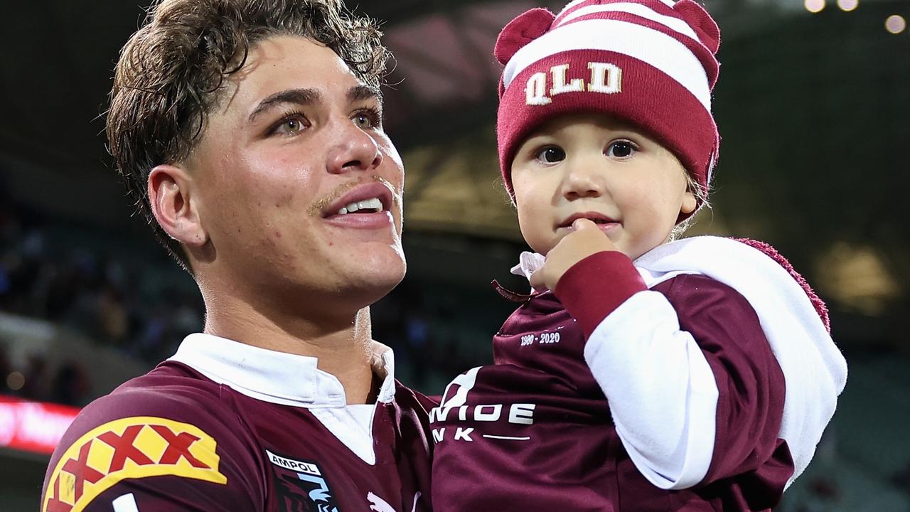 Reece Walsh walks onto the field with his daughter.