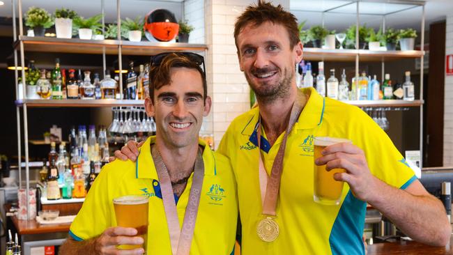 Damien Schumann and Chris McHugh toast their Comm Games gold medals at Henley Beach this month. Picture: Brenton Edwards (AAP).